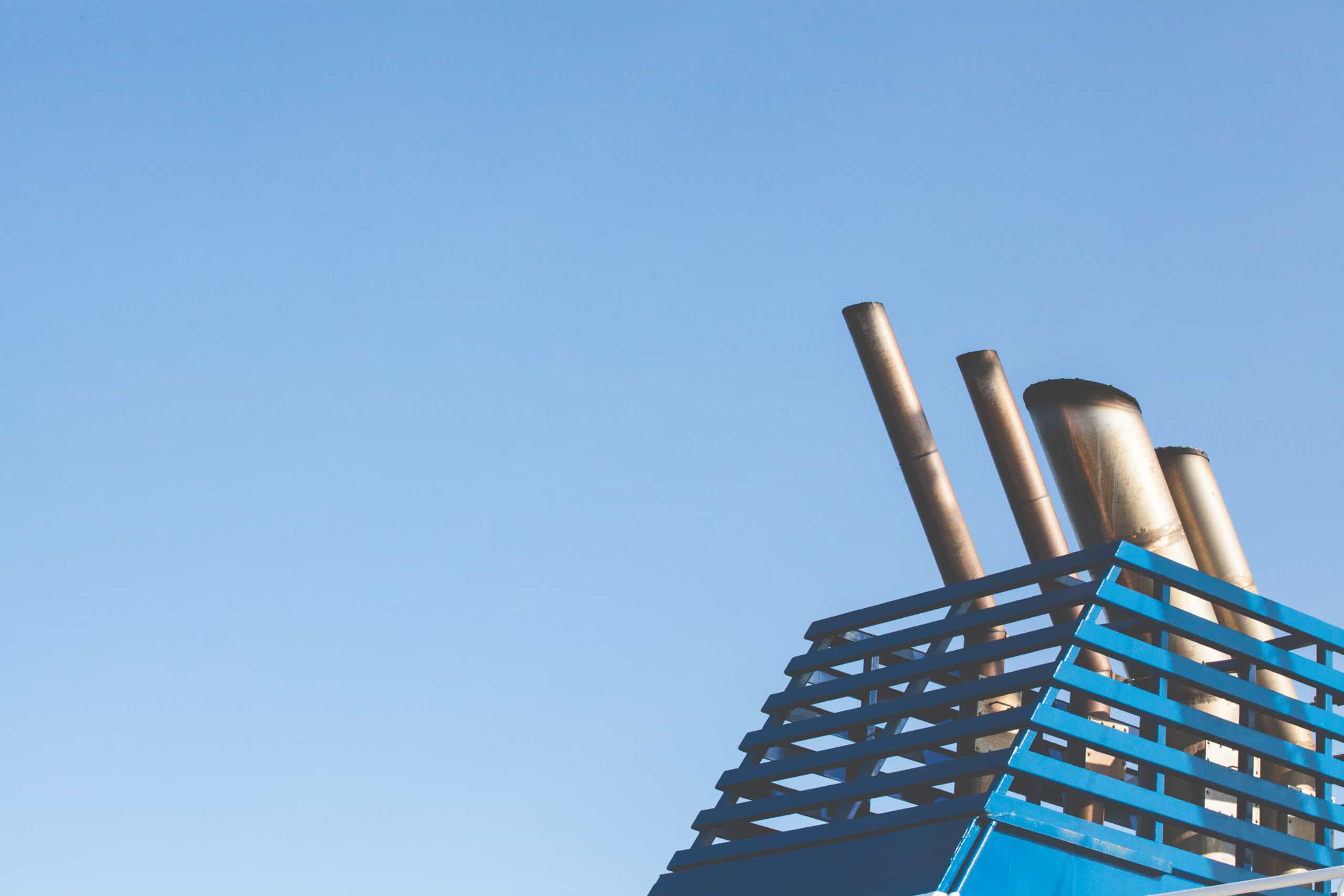 close up of industrial chimney with blue sky background