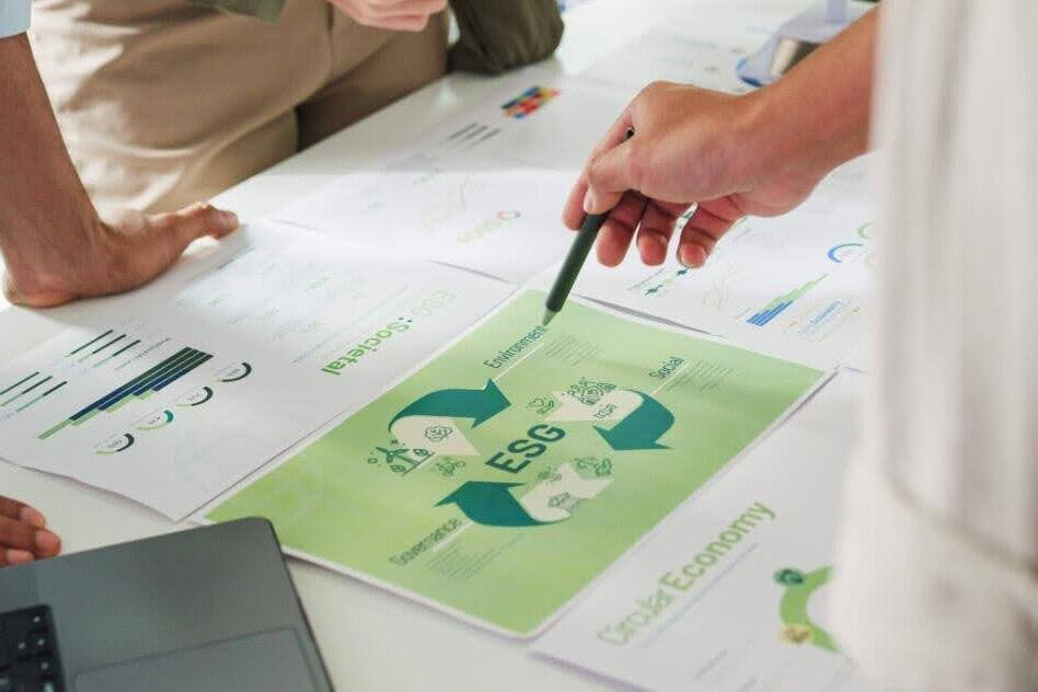 Work table covered in sheets of paper that outline ESG strategy while people are discussing it