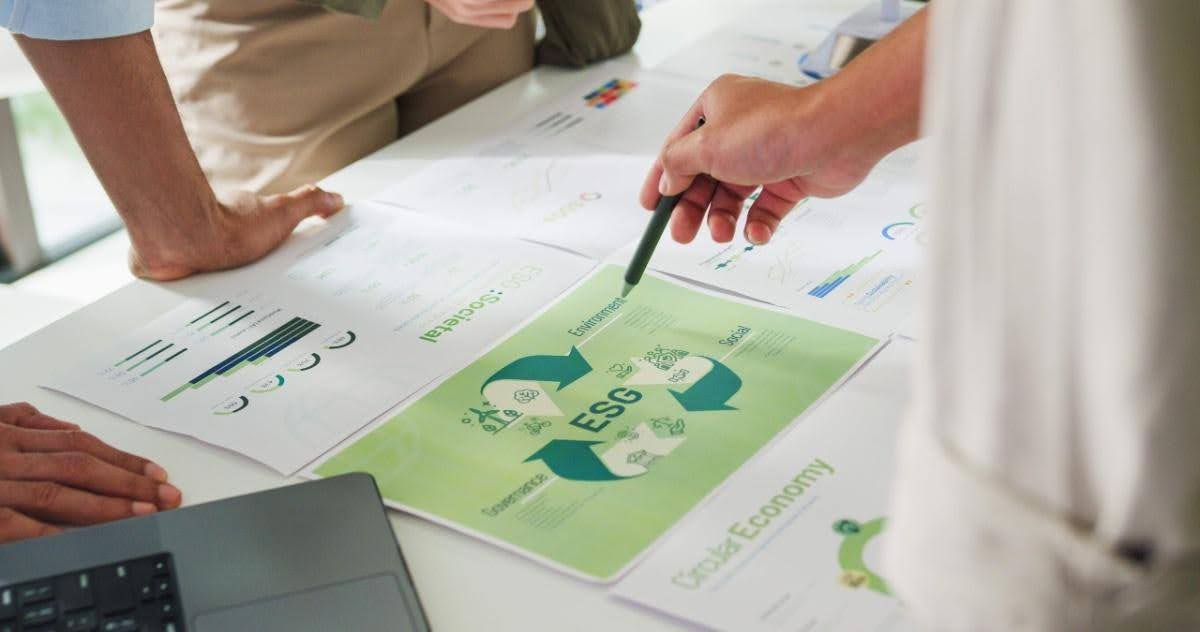 Work table covered in sheets of paper that outline ESG strategy while people are discussing it